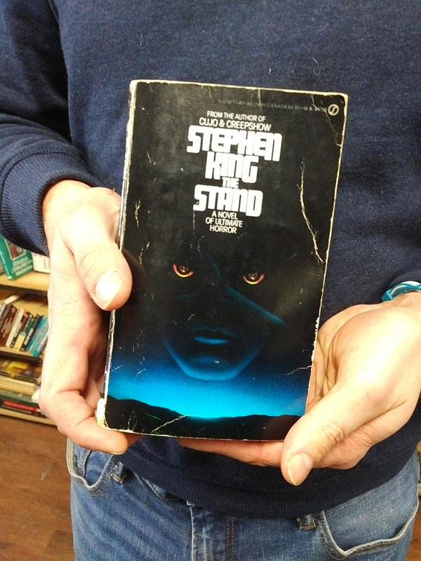Silent book club participant holds the book The Stand by Stephen King