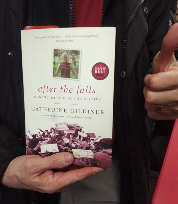 Silent book club participant holds the book After the Falls by Catherine Gildiner