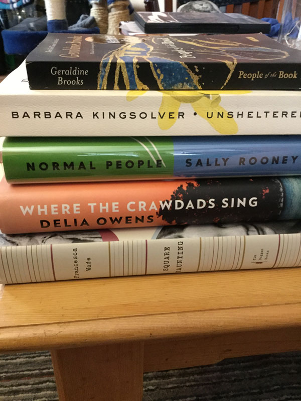 Stack of books read by silent book club members