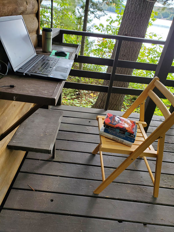 Computer and chair on bunkie porch, preparing for silent book club zoom meeting
