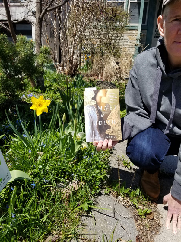 Sue R in the garden with a book