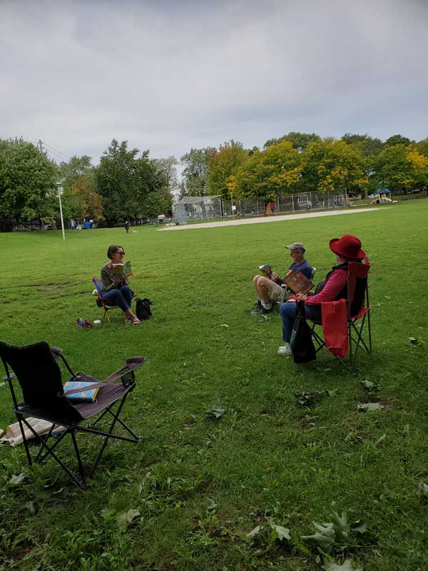 Silent book club group reading in the park