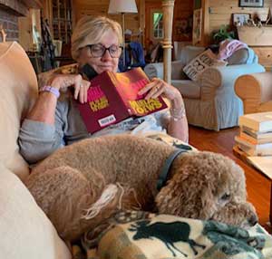 Silent book club member Sue Wright, reading Miriam Toews' Fight Night, in the company of her dog Ruby