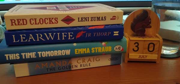 Kathryn E's stack of recent reading, with a squirrel calendar set to July 30th