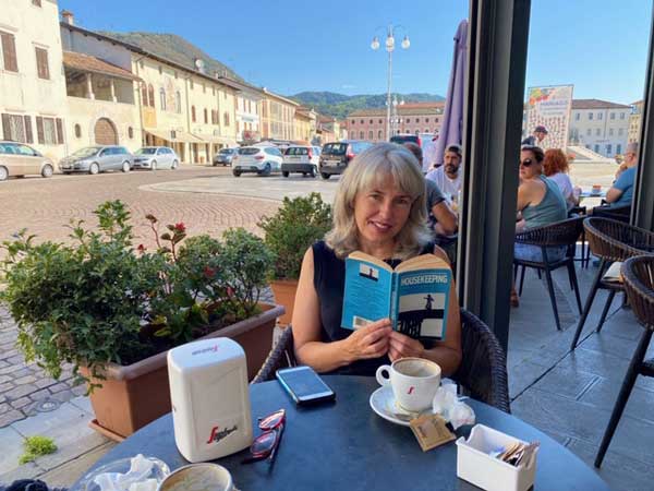 Catherine, reading Housekeeping by Marilynne Robinson, in Italy