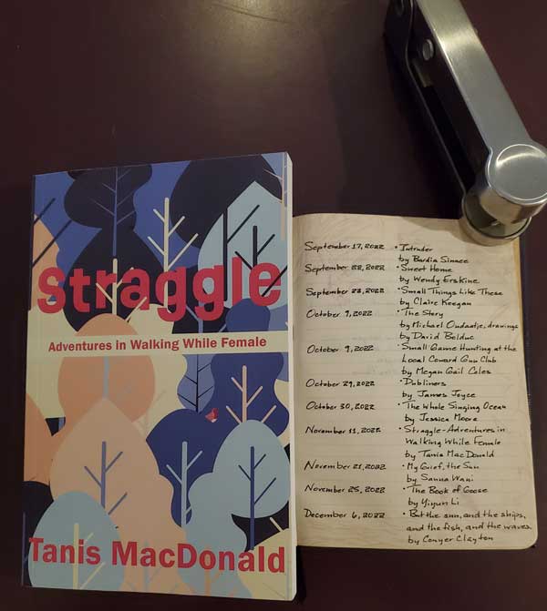 My 2022 year in reading, reflected in a page of my handwritten Book of Books, next to the essay and poetry collection Straggle by Tanis MacDonald