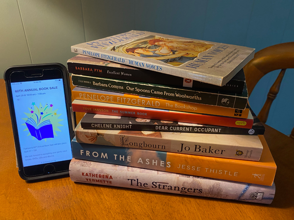 Silent book club member Anne-Louise acquired a stack of delicious books from the Fairlawn United Church book sale, the event for which is shown on a phone screen next to a stack of books which includes Human Voices by Penelope Fitzgerald and From the Ashes by Jesse Thistle