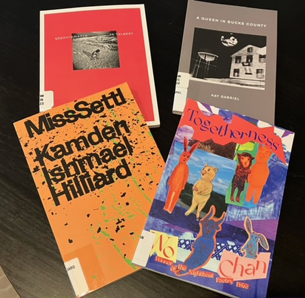 Silent book club member Catherine borrowed a bundle of colourful poetry chapbooks from the New York Public Library, shown here displayed on a black tabletop