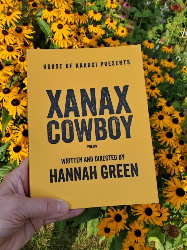 Xanax Cowboy by Hannah Green, with bright yellow cover, held up amidst equally bright blackeyed susans
