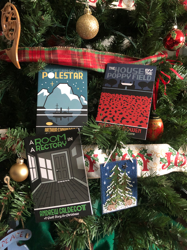 Books from the Biblioasis Christmas Ghost Stories package are arranged on the branches of a Christmas tree
