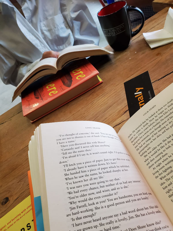 Silent book club readers with their books open at the table at East Toronto Coffee Co