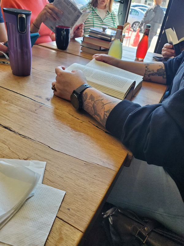 Silent book club members gathered, reading silently, at a table at East Toronto Coffee Co