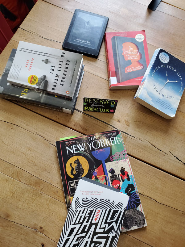 Books on the table at East Toronto Coffee Co, just before the start of the silent book club meeting, including a copy of The New Yorker and Stories of Your Life and Others by Ted Chiang