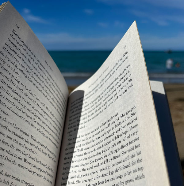 Silent book club member Lisa reads on a Hawaiian beach [Photo by Lisa]