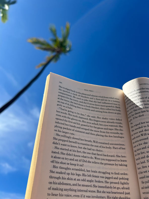 Silent book club member Lisa reads on a Hawaiian beach [Photo by Lisa]