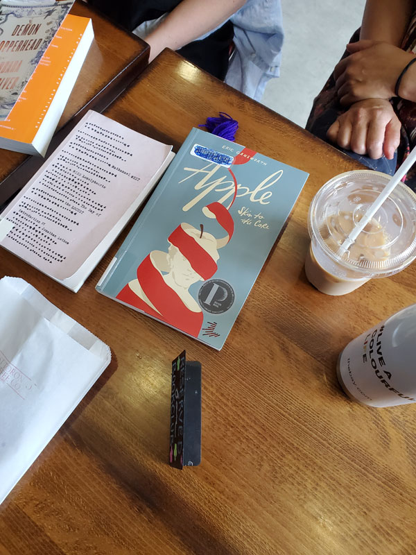 Group book pile at East Toronto Coffee Co, accompanied by coffees, cookies and pastries