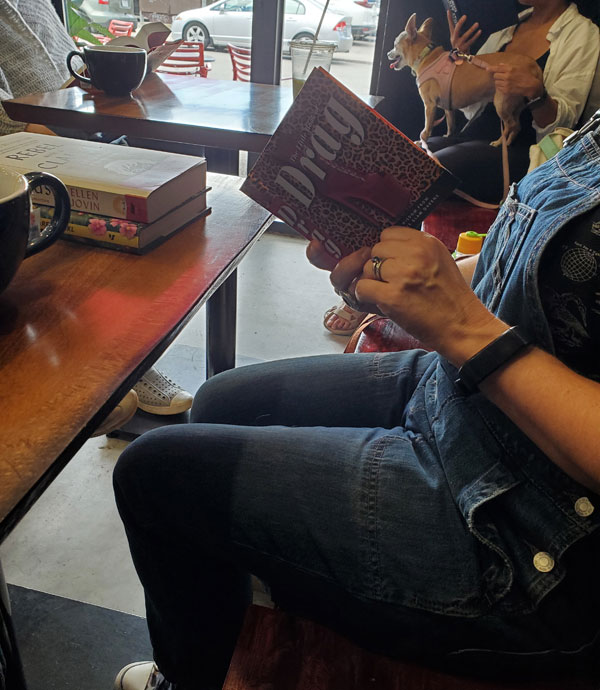 Book club members, including Lola the chihuahua, reading at East Toronto Coffee Co