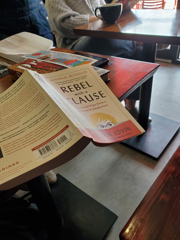 The book Rebel with a Clause: Tales and Tips from a Roving Grammarian by Ellen Jovin sits on a table at East Toronto Coffee Co during a silent book club meeting