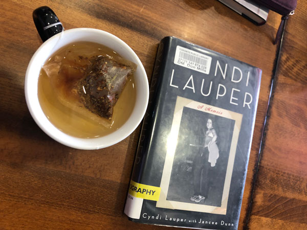 The book Cyndi Lauper: A Memoir by Cyndi Lauper with Jancee Dunn sits on a table at East Toronto Coffee Co with a cup of tea. - Photo by Jennifer D. Foster