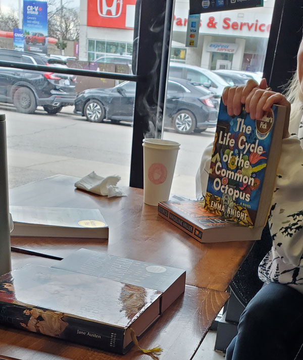 Group book pile at East Toronto Coffee Co, accompanied by coffee and pastries (Photo by Vicki Ziegler)