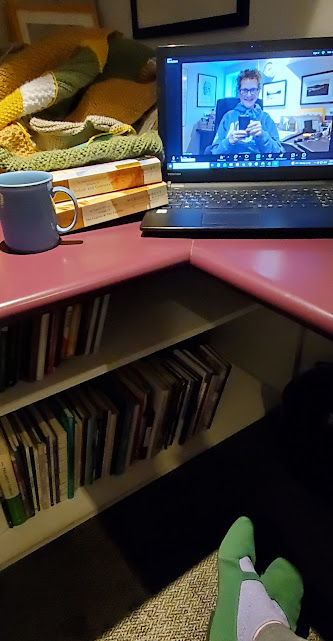 Silent book club member Vicki (that's me, with my signature messy hair and glasses), on screen getting ready for our zoom meeting, with books stacked next to my computer, including works by Marcel Proust (Photo by Vicki Ziegler)