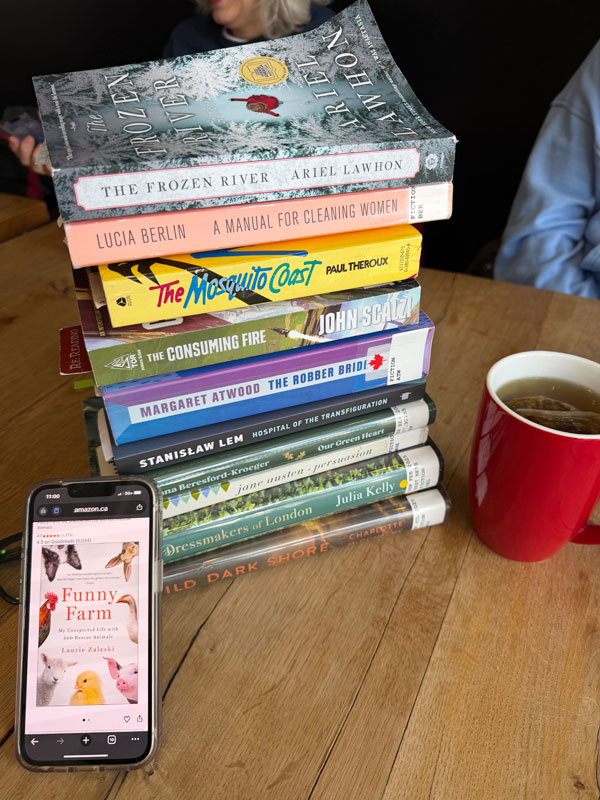 Group book pile at East Toronto Coffee Co, including titles by Margaret Atwood, John Scalzi, Stanislaw Lem, Jane Austen + more (Photo by Jennifer D. Foster)