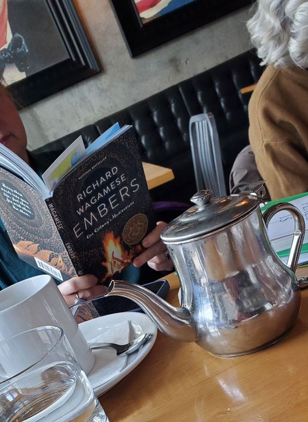 Reader reading at East Toronto Coffee Co, accompanied by tea (Photo by Vicki Ziegler)