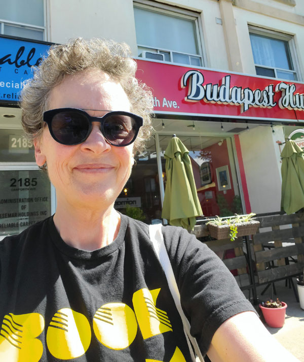 Silent book club member Vicki (moi), in her Book City T-shirt, in front of Budapest Restaurant on the Danforth (Photo by Vicki Ziegler)
