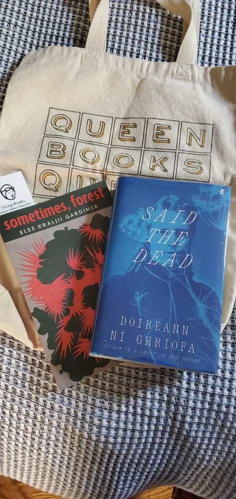 Silent book club member Vicki's Queen Books book bag is the background for sometimes, forest by Elee Kraljii Gardiner and Said the Dead by Doireann Ní Ghríofa (Photo by Vicki Ziegler)