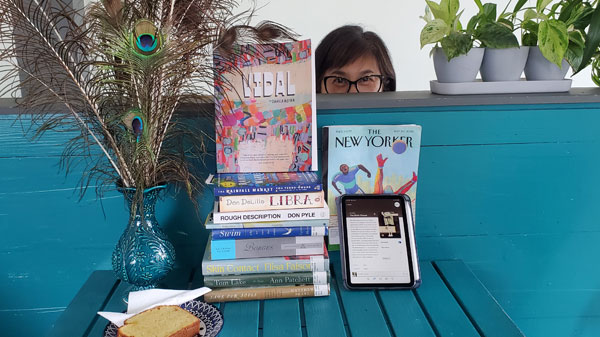Silent book club member Joylyn takes a peek at the group book pile. (Photo by Vicki Ziegler)
