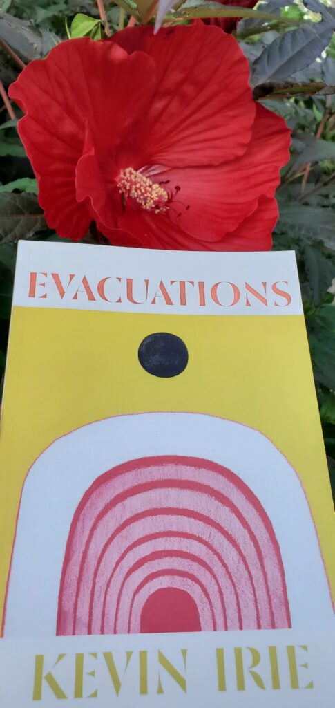  Poetry collection Evacuation by Kevin Irie (University of Alberta) held up next to a bright red hibicus