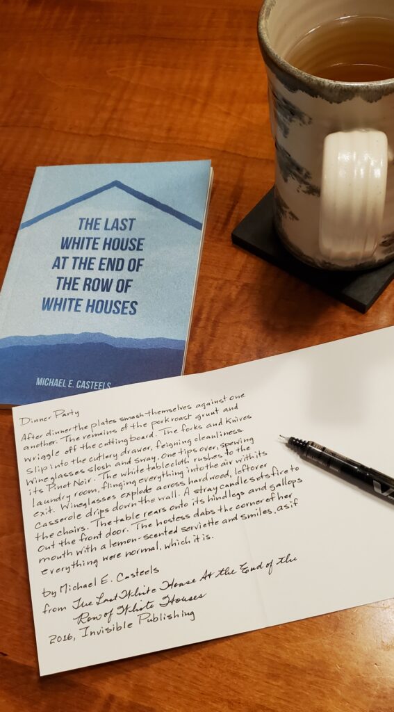 Handwritten transcription in a greeting card of a poem from the poetry collection The Last White House at the End of the Row of White Houses by Michael e. Casteels (Invisible Publishing), with the book sitting nearby along with a mug of tea