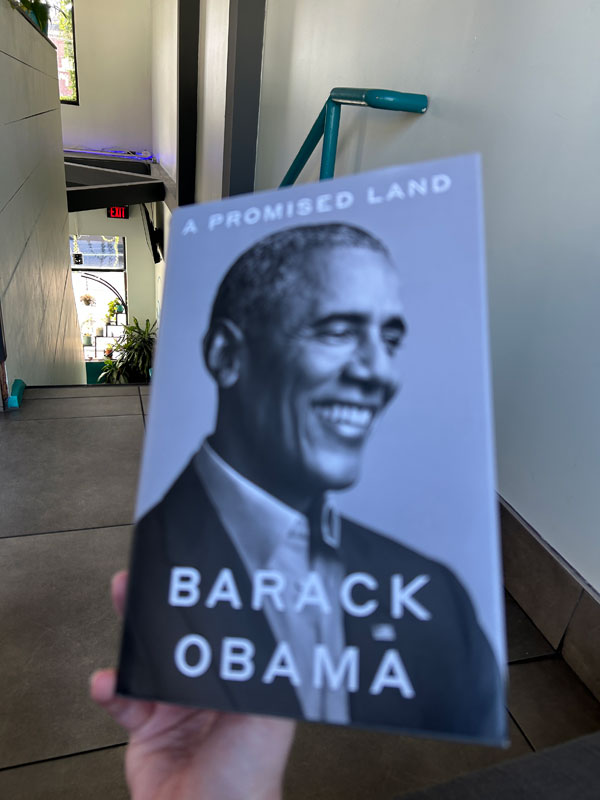 Silent book club member Ruth holds up her reading, A Promised Land by Barack Obama (Photo by Ruth Bartlett)